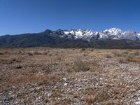 a large open field with mountains in the background on a clear day at high altitude