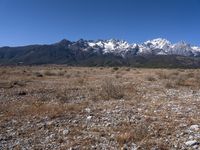 a large open field with mountains in the background on a clear day at high altitude