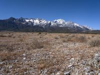 a large open field with mountains in the background on a clear day at high altitude