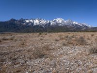 a large open field with mountains in the background on a clear day at high altitude