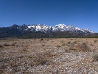 a large open field with mountains in the background on a clear day at high altitude