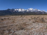 a large open field with mountains in the background on a clear day at high altitude