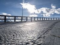 a paved road with large fence near the top of it and snow on the ground