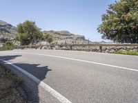 a bike is shown in the view while driving down a mountain road past some trees