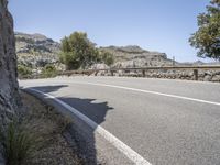 a bike is shown in the view while driving down a mountain road past some trees