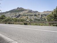 a bike is shown in the view while driving down a mountain road past some trees