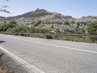 a bike is shown in the view while driving down a mountain road past some trees