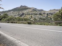 a bike is shown in the view while driving down a mountain road past some trees