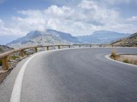 a person riding a bike up the side of a mountain road in front of a body of water