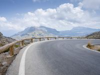 a person riding a bike up the side of a mountain road in front of a body of water