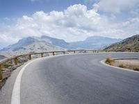 a person riding a bike up the side of a mountain road in front of a body of water