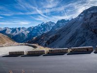 a mountain road running alongside the top of snowy mountains in switzerland and france at the same time
