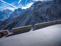 a mountain road running alongside the top of snowy mountains in switzerland and france at the same time