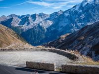 a mountain road running alongside the top of snowy mountains in switzerland and france at the same time