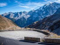 a mountain road running alongside the top of snowy mountains in switzerland and france at the same time