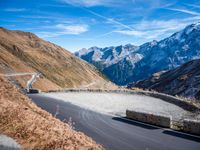 a mountain road running alongside the top of snowy mountains in switzerland and france at the same time