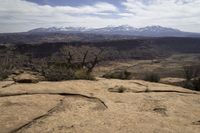 the view from atop the rock trail in a desert mountain range with mountain views visible in the distance