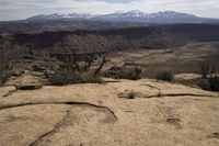 the view from atop the rock trail in a desert mountain range with mountain views visible in the distance