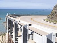 the view from behind the highway overlooks at a mountain near an ocean shoreline area