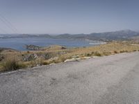 a person on a skateboard rides down the road with mountains in the background,