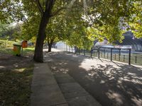 a scenic river path along an urban waterfront with buildings in the background and tree lined streets