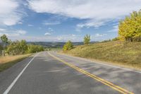 a scenic scenic country road winding towards a scenic mountain area with pine trees on either side