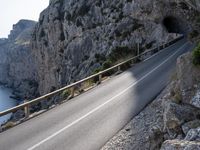 a motorcycle is parked on the road near the ocean and mountainside in turkey on an autumn day