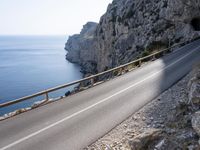 a motorcycle is parked on the road near the ocean and mountainside in turkey on an autumn day