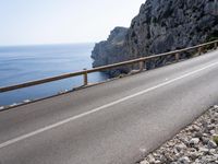 a motorcycle is parked on the road near the ocean and mountainside in turkey on an autumn day