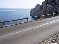 a motorcycle is parked on the road near the ocean and mountainside in turkey on an autumn day