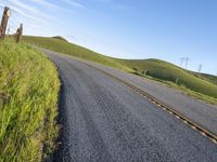 the road stretches along the hill side to the distant hills, with yellow stripes on the edge