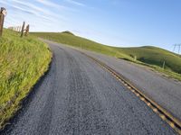 the road stretches along the hill side to the distant hills, with yellow stripes on the edge