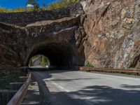 a road goes into a tunnel and through the hill to the other side of it