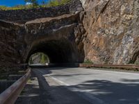 a road goes into a tunnel and through the hill to the other side of it