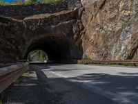 a road goes into a tunnel and through the hill to the other side of it