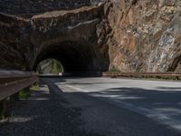 a road goes into a tunnel and through the hill to the other side of it