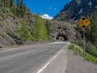 a road goes into a tunnel and through the hill to the other side of it