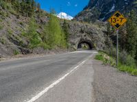 a road goes into a tunnel and through the hill to the other side of it