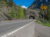 a road goes into a tunnel and through the hill to the other side of it