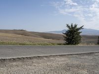 there is a person riding their bicycle down the road and a view in the background