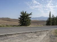 there is a person riding their bicycle down the road and a view in the background