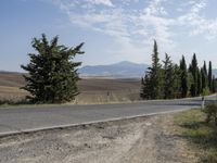 there is a person riding their bicycle down the road and a view in the background