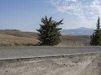 there is a person riding their bicycle down the road and a view in the background