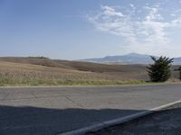 there is a person riding their bicycle down the road and a view in the background