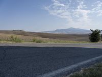 there is a person riding their bicycle down the road and a view in the background