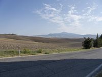 there is a person riding their bicycle down the road and a view in the background