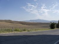 there is a person riding their bicycle down the road and a view in the background