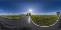 a couple of wide angle shots of a paved road with sun shining on the horizon