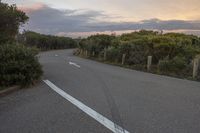 the view from a distance of a single long road with two white arrows pointing in opposite directions