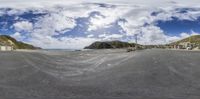 a fish eye lens is shown to show a road and the view of mountains, sand, and beach